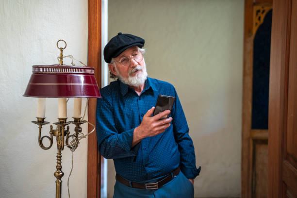 Elderly man is using his cell phone at the retirement home​