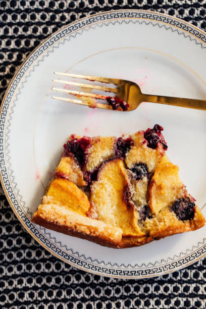 istock eating a slice of blackberry peach Flaugnarde 1991193351