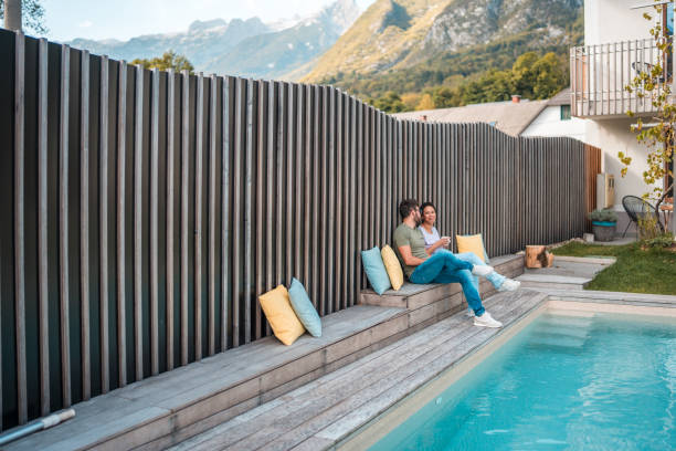 A Woman Enjoys Ultimate Relaxation,Floating Weightlessly on her Back in the Calm,Clear Waters of an Infinity-Edge Swimming Pool. Only her Face,Hands,and Feet Emerge From the Water,Which Mirrors the Soft Light of the Sky. The Stunning Backdrop Features Expansive,Verdant Rolling Hills Dotted with Trees and a Distant Village,All Under a Hazy,Bright Sky. This Image Captures a Profound Sense of Peace,Tranquility,and a Luxurious Escape into Nature. Perfect for Wellness,Travel,and Lifestyle Concepts