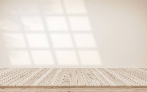 istock Minimalistic abstract gentle light beige background for product presentation with light and shadow of window and leaf curtains on wall. Pastel cream watercolor concrete wall old on floor wood parquet. 1991210564