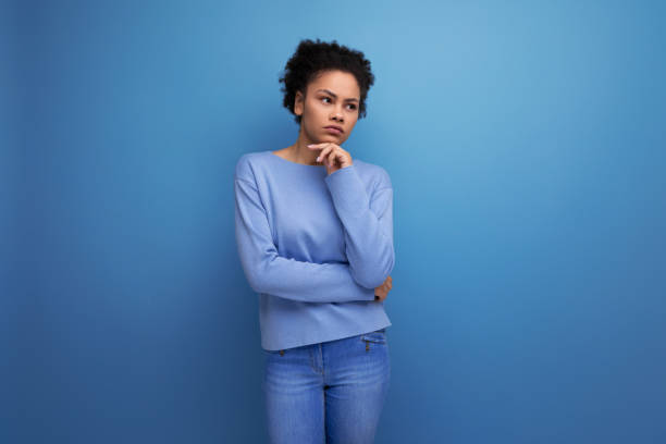 istock thoughtful young brunette woman with afro curls thinking about an idea 1991248298