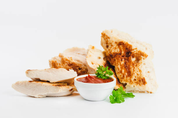 Chicken fillets fried until half cooked, semi-finished product with fresh herbs on a white background. Fast cooking.Fast homemade food.Fast food. Quick cooking at home. Copy space.