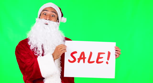 Sale poster, Christmas and Santa Claus on green screen for holiday, festival and celebration. Advertising, festive season and portrait of male person with sign for discount, bargain or deal in studio
