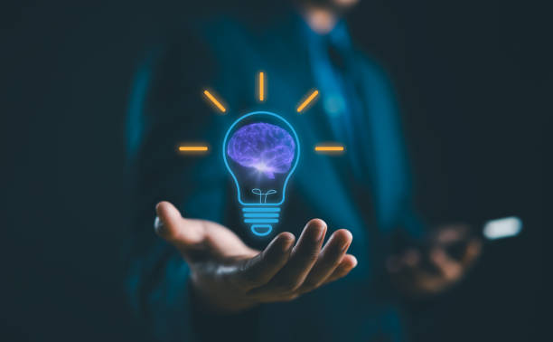 istock Hand holding drawing virtual lightbulb with brain on dark blue background for creative and smart thinking idea concept. new idea, innovation and inspiration, creativity. 1991357252