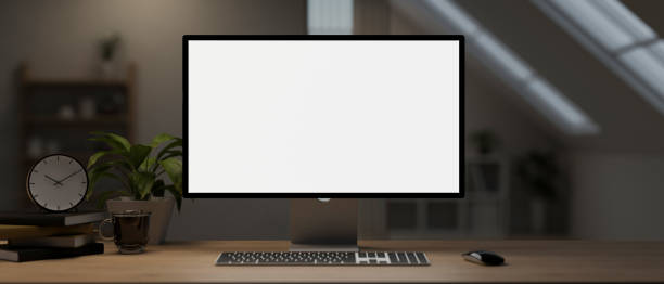 istock A computer desk with a computer mockup and accessories on a hardwood table in a room. 1991448805