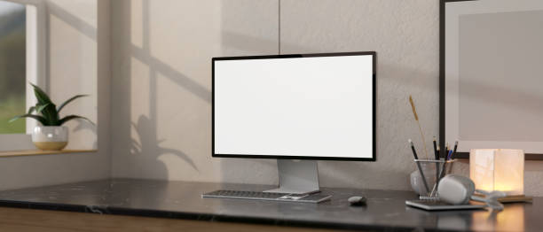 istock Close-up image of a white-screen computer mockup on a black marble table in a modern home office. 1991448817