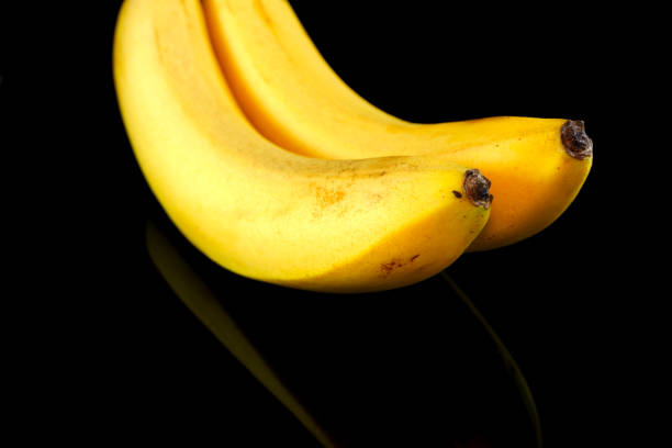 istock Bananas isolated on black background close-up view, copy space 1991519109