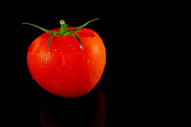 istock Fresh single tomato isolated on black background close-up view, Single object concept, Copy space, No people 1991519121