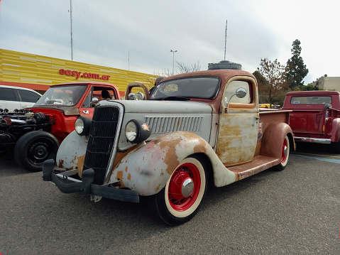 Buenos Aires, Argentina - Jun 4, 2023: An old aged unpainted 1935 Ford V8 model 48 pickup truck at a classic car show in a parking lot.