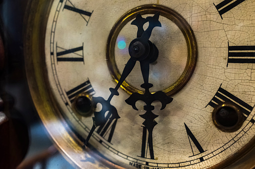 Ancient ornamental clock face with roman numbers isolated on a white background