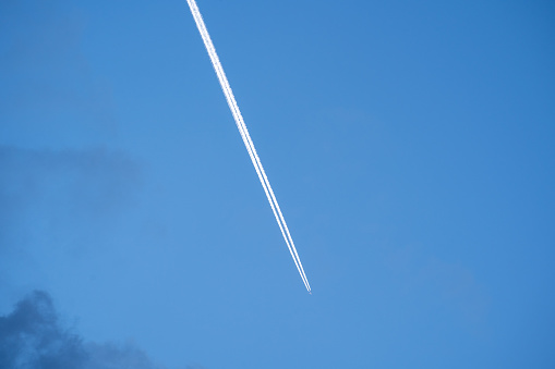 White airplane contrails in the blue evening sky