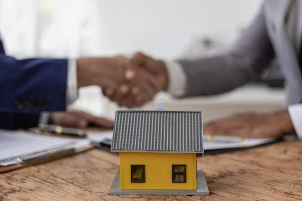 istock Real estate agent and client shaking hands after contract is finalized after home insurance and investment loan related to home loan. Successful formal business conversation 1991690370