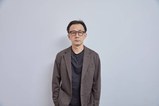 istock Handsome Asian businessman in suit, look at camera on grey background. 1991705456