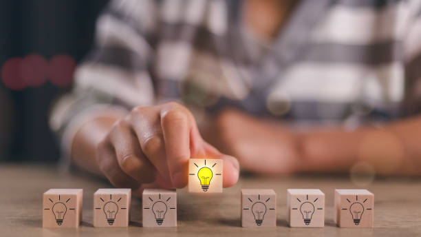istock Wooden blocks with light bulbs and yellow color icons and copy space. Creative idea, solution, and innovation concept. Idea generation and screening for the product development process. 1991717826