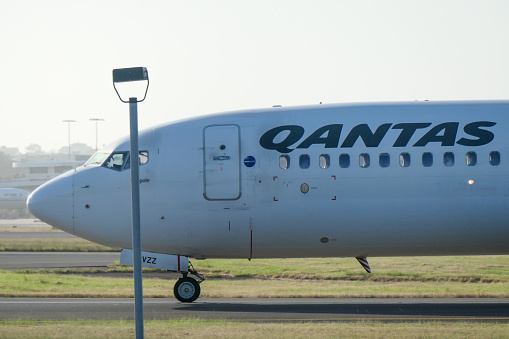 A Qantas Boeing B737-838 plane, registration VH-VZZ, taxiing at Sydney Kingsford-Smith Airport in preparation for departure as flight QF147 to Auckland. The plane is named \