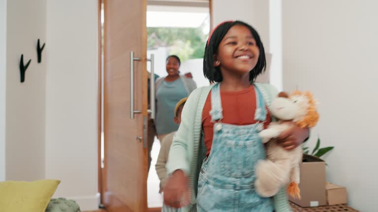 Happy black family, door and children in new home, property or investment in shelter together. African mother, father and kids smile, running or moving in house, real estate or relocation at entrance