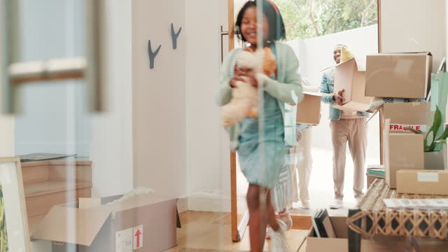 Children, parents and front door at new home with boxes, moving and excited for fresh start with property. Mother, father and kids with smile, toys and running for real estate, investment or mortgage