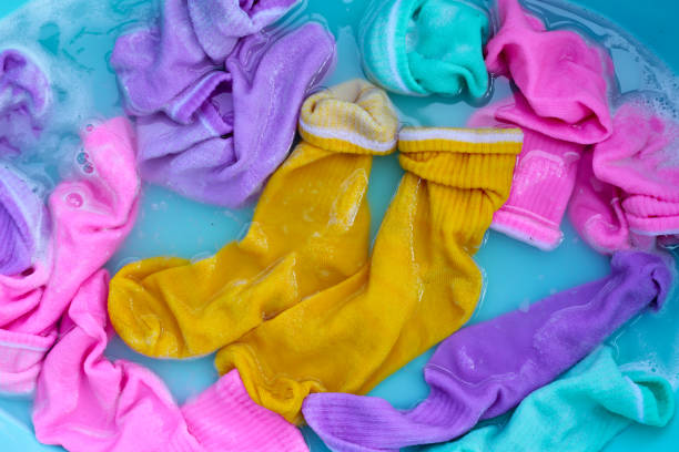 istock Dirty socks soaked in water, dissolving detergent in basin. 1991846401