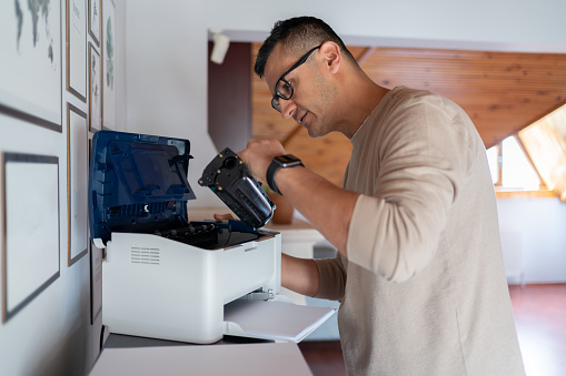 Man Replacing Toner Cartridge In A Laser Printer At Home