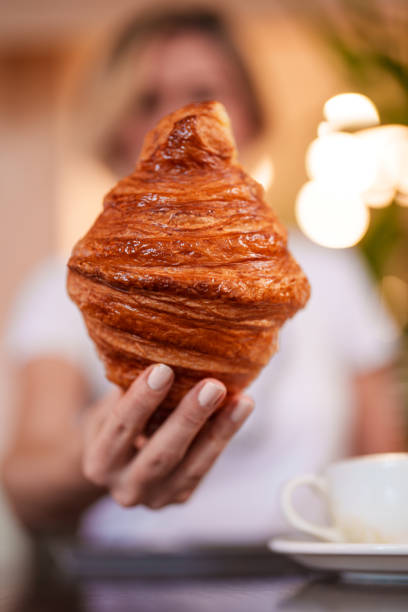 istock Selective focus on woman hand holding a croissant 1991882362