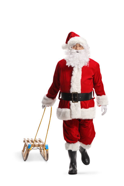 istock Santa Claus walking towards camera and pulling a wooden sled 1991917692