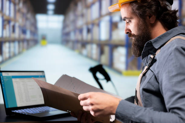 istock Industrial worker reading shipment invoice details in warehouse 1991935445