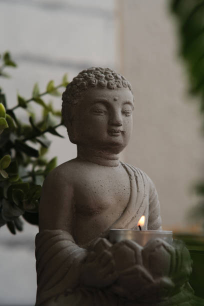 istock stone statue of buddha with a candle 1991936496