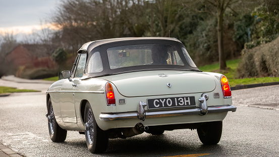 Milton Keynes,UK-Feb 4th 2024: 1969 white MGB classic car  driving on an English road.