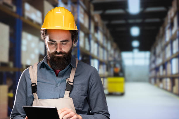 istock Warehouse worker verifying list of stock packages stored on racks 1991944905