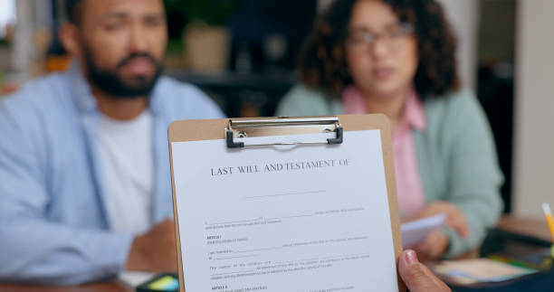 istock Closeup, hand and last will for document in office for testament, insurance or future planning. Funeral, death and preparation of married couple in home for protection, security of safety of family 1991952619