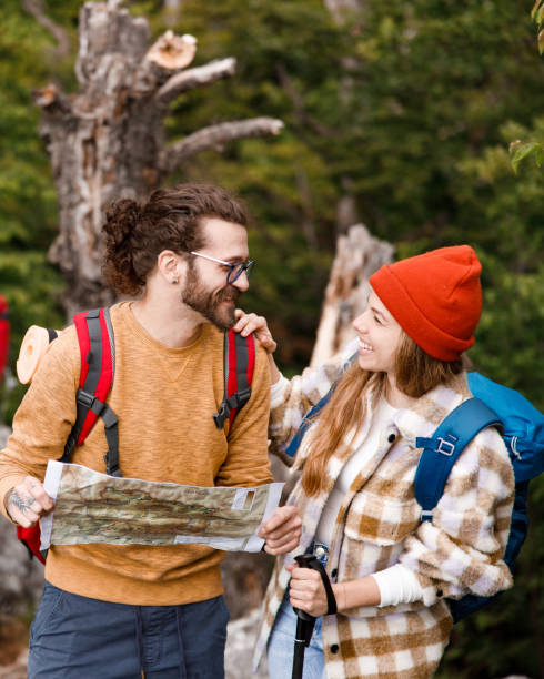 istock Happy couple of hikers talking while reading a map in the forest. 1991953790
