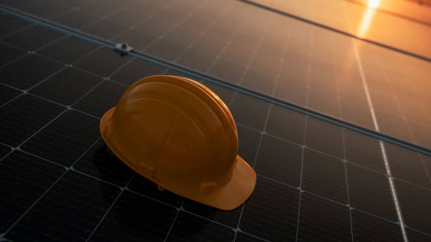 istock Yellow engineer hard safety helmet hat on solar cell panel. Clean energy concept. 1991958024
