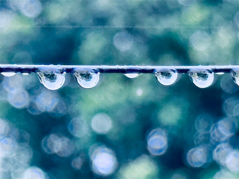 Close up shot of water droplets on the clothes line after raining in the morning. Bright in Shallow depth of field.