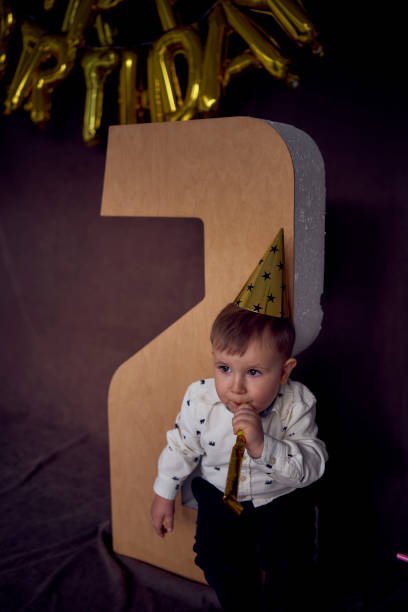 istock a toddler in a party cap blows a whistle flute 1991975963
