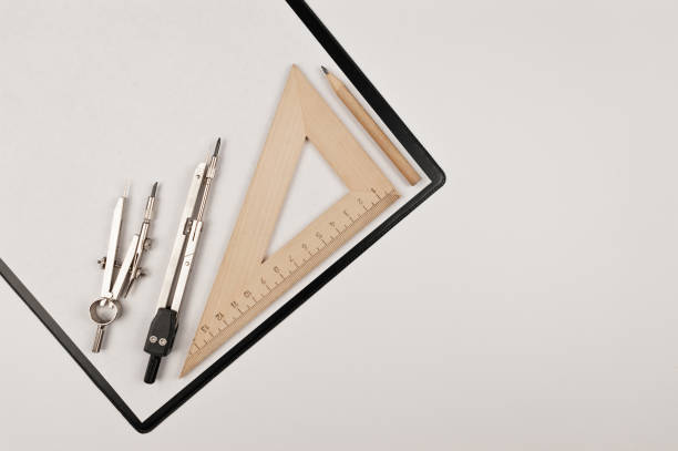 Top view of black clipboard, white blank, triangle ruler, compasses and pencil on white background. Architecture drawing flat lay, copy space.