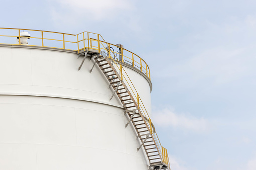 White fuel oil storage tank with blue sky background, Storage tank important infrastructure for oil and gas, The storage tank place to receive and store oil at fuel terminal, Oil and Gas storage tank.