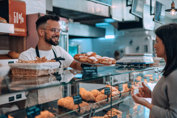 istock Male bakery attendant assists happy customer 1992036274
