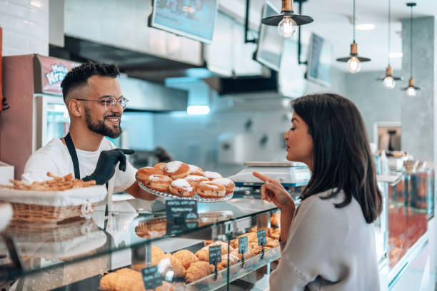 istock Bakery employee helping with donut choices 1992036597