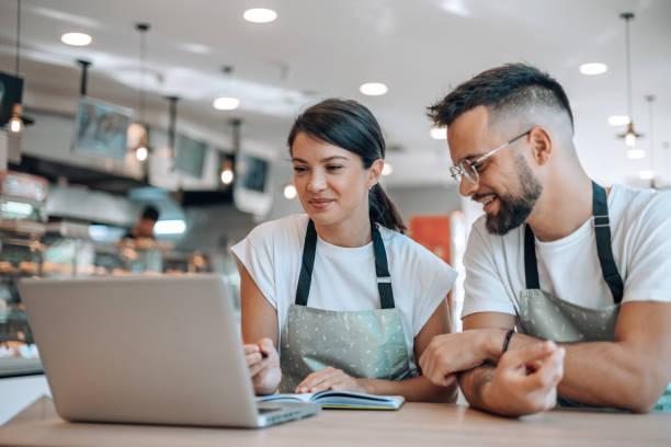 istock Colleagues collaborating with laptop in bakery 1992036918