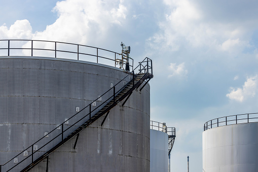 White fuel oil storage tank with blue sky background, Storage tank important infrastructure for oil and gas, The storage tank place to receive and store oil at fuel terminal, Oil and Gas storage tank.