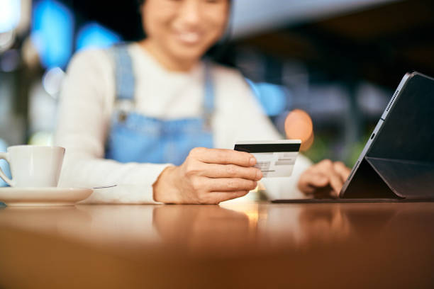 istock Focus on the female hand, holding and using a credit card, entering data into the tablet. 1992043477