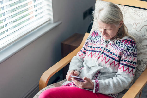 istock A middle aged woman,using her smartphone,at home,checking up on friends,Worcestershire,England,UK. 1992044552