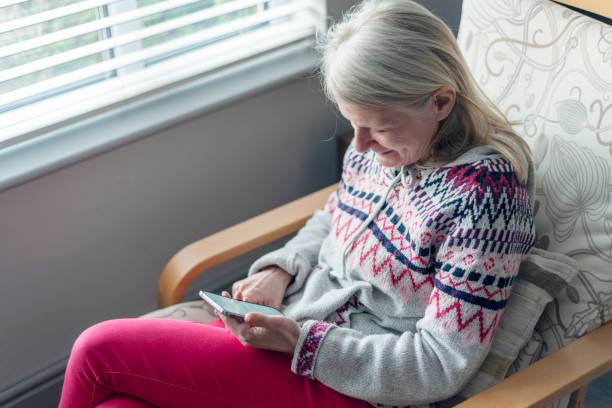 istock A middle aged woman,using her smartphone,at home,checking up on friends,Worcestershire,England,UK. 1992044632