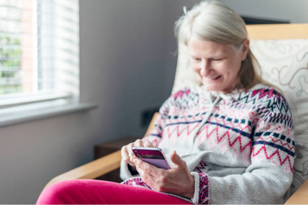 istock A middle aged woman,using her smartphone,at home,checking up on friends,Worcestershire,England,UK. 1992048196