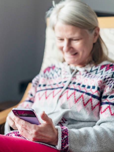 istock A middle aged woman,using her smartphone,at home,checking up on friends,Worcestershire,England,UK. 1992048197