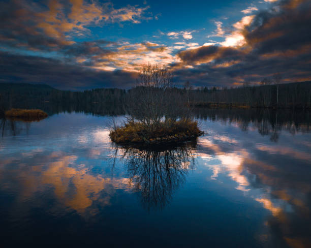 The sunset clouds over a small island in the water