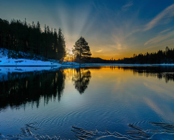 istock Serene lake illuminated by vibrant sunbeams at sunset 1992048208
