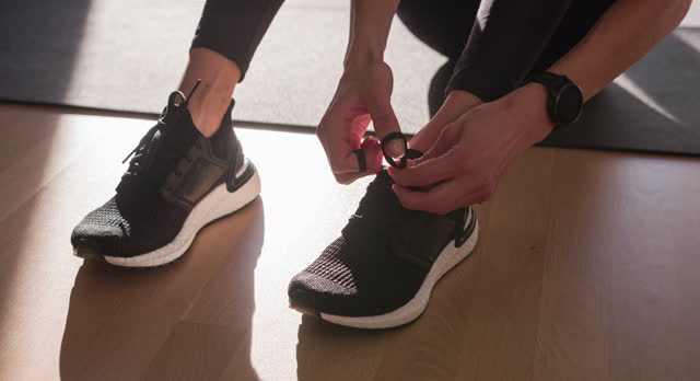 Fitness woman tying shoelaces on sports shoe, getting ready for run