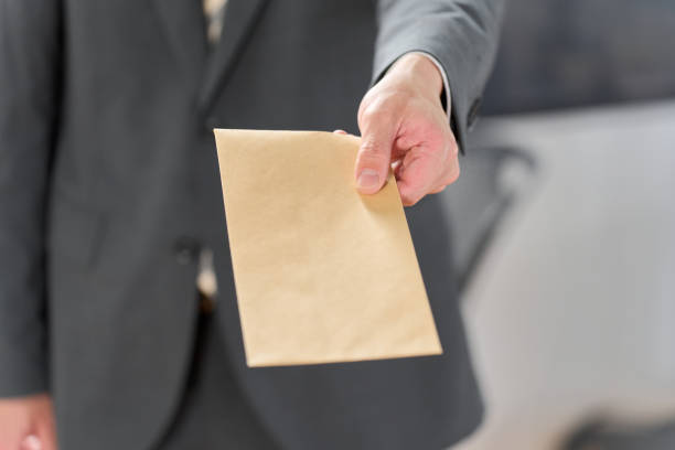 istock Businessman holding out an envelope 1992053015