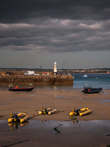 St Ives, Cornwall, England, UK - May 30, 2022: Dark clouds in the evening and boats in the harbour at low tide